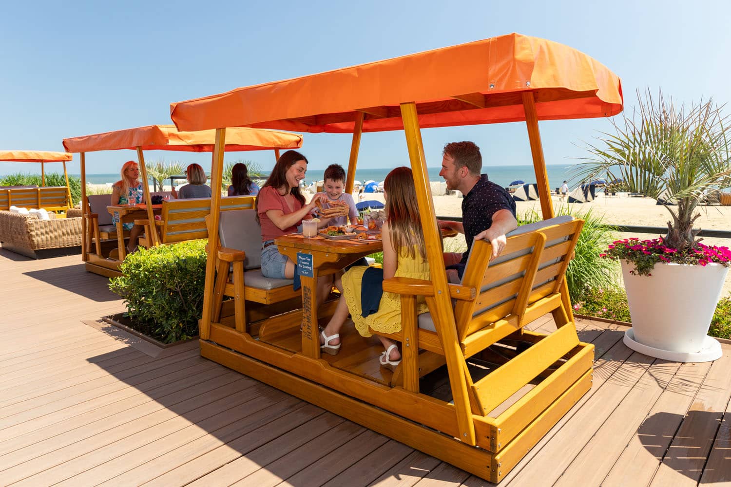 A family enjoying an oceanfront meal at The Deck Seagrill & Bar