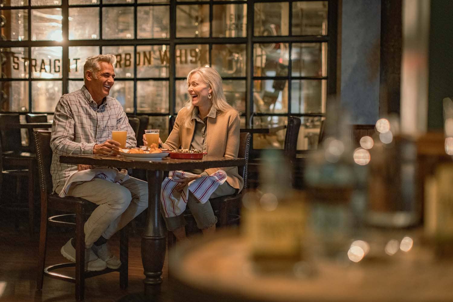 A couple sharing a meal and drinks inside the Hunt Room restaurant