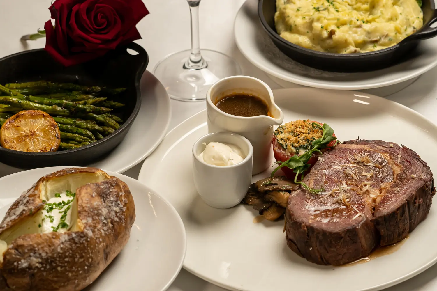 A prime rib with sides on a table at Becca Restaurant & Garden