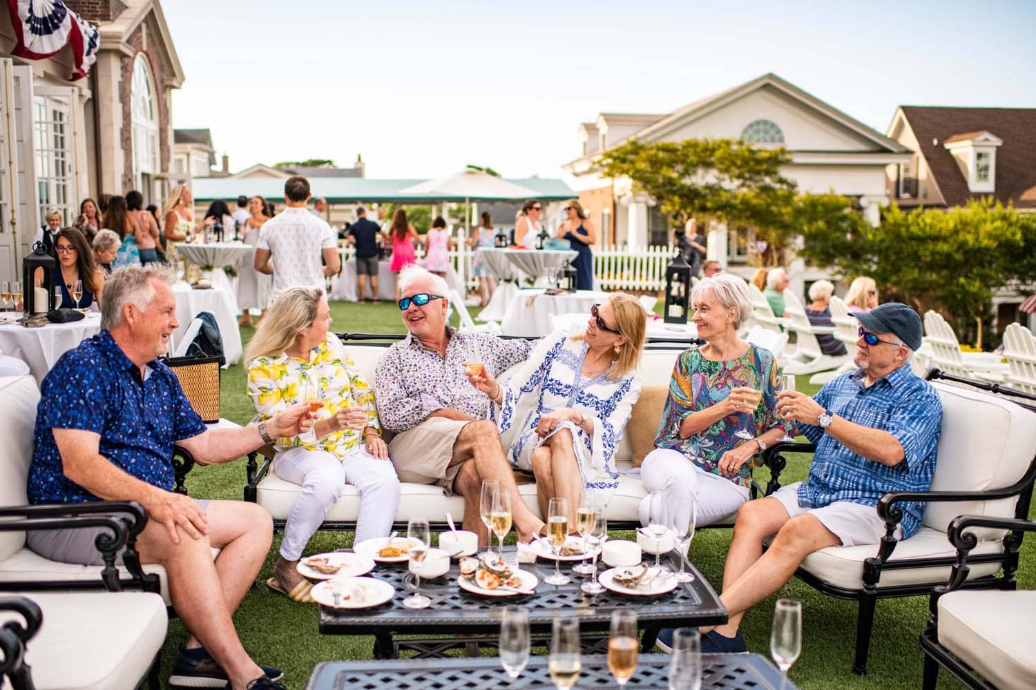 A group of people sitting outside on the Great Lawn at The Historic Cavalier Hotel