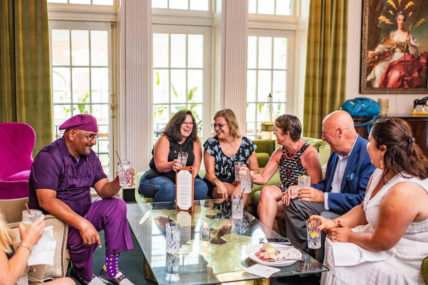 A group of people sitting in lounge chairs inside The Raleigh Room