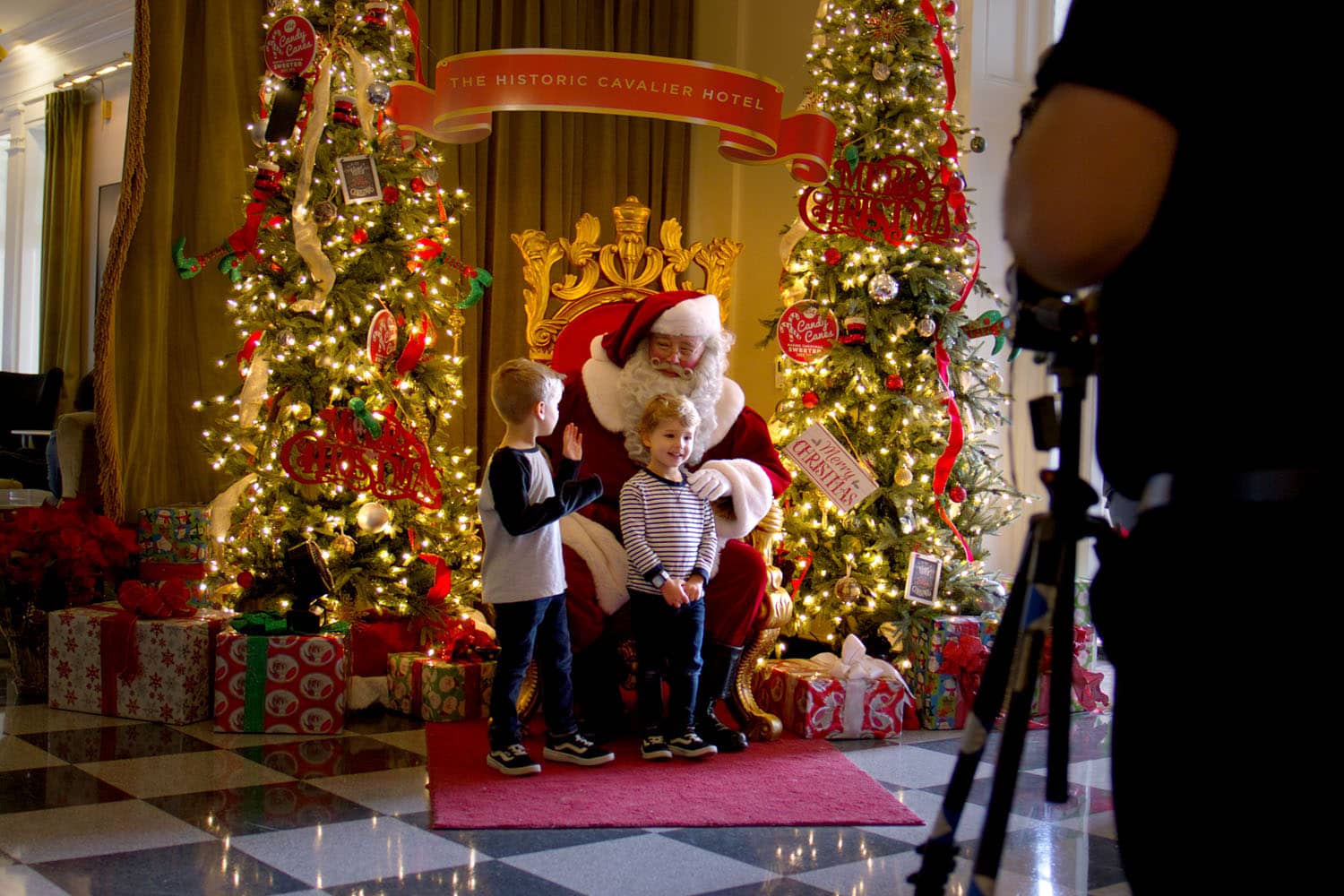 Santa holding two children on his lap for a photo