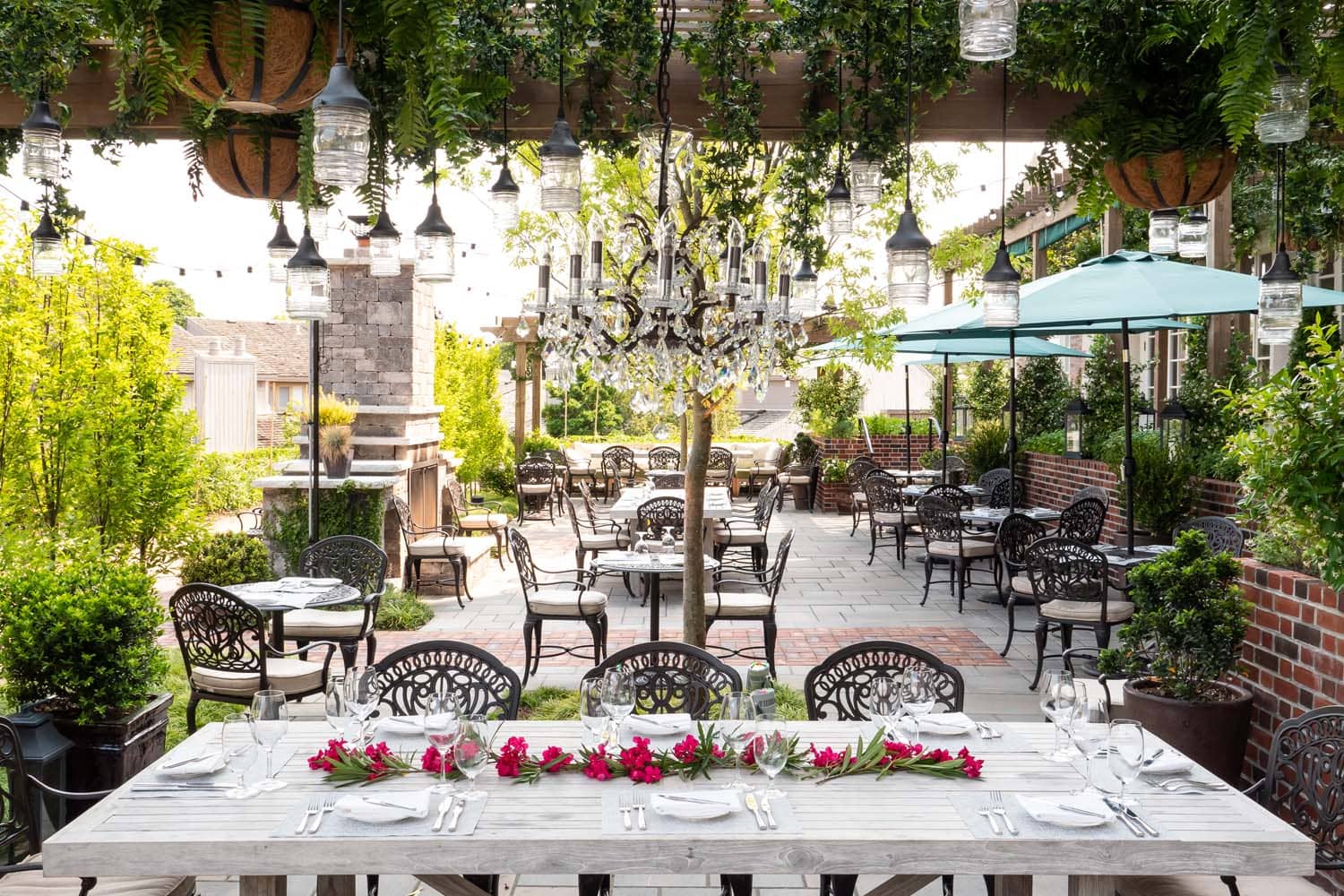 A decorated table with flowers inside the garden at Becca Restaurant