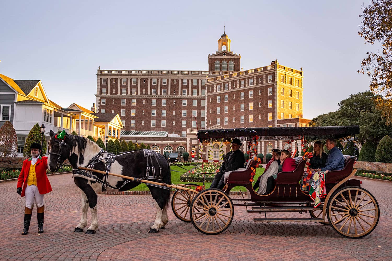 A family on a horse-drawn carriage in front of The Cavalier Hotel