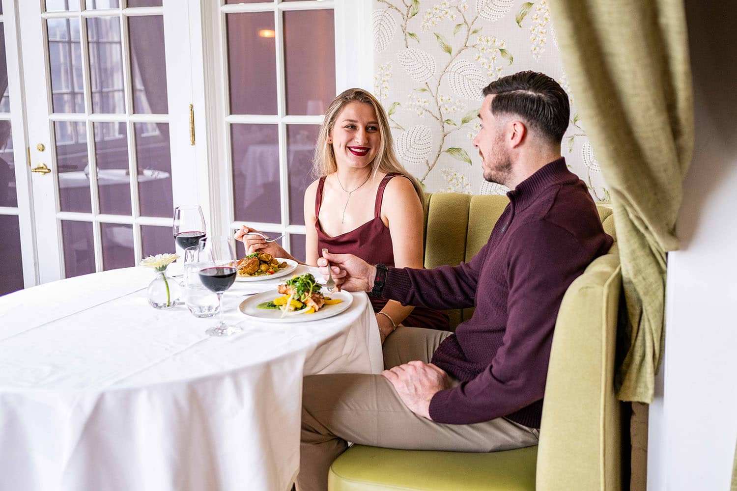 A couple eating dinner inside Becca Restaurant & Garden