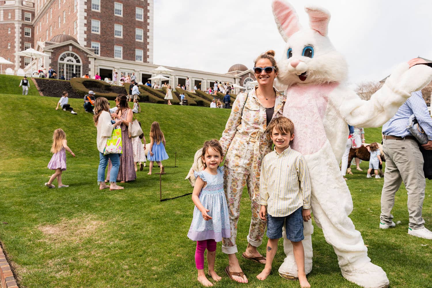 The Easter Bunny posing for a photo with a family on a lawn