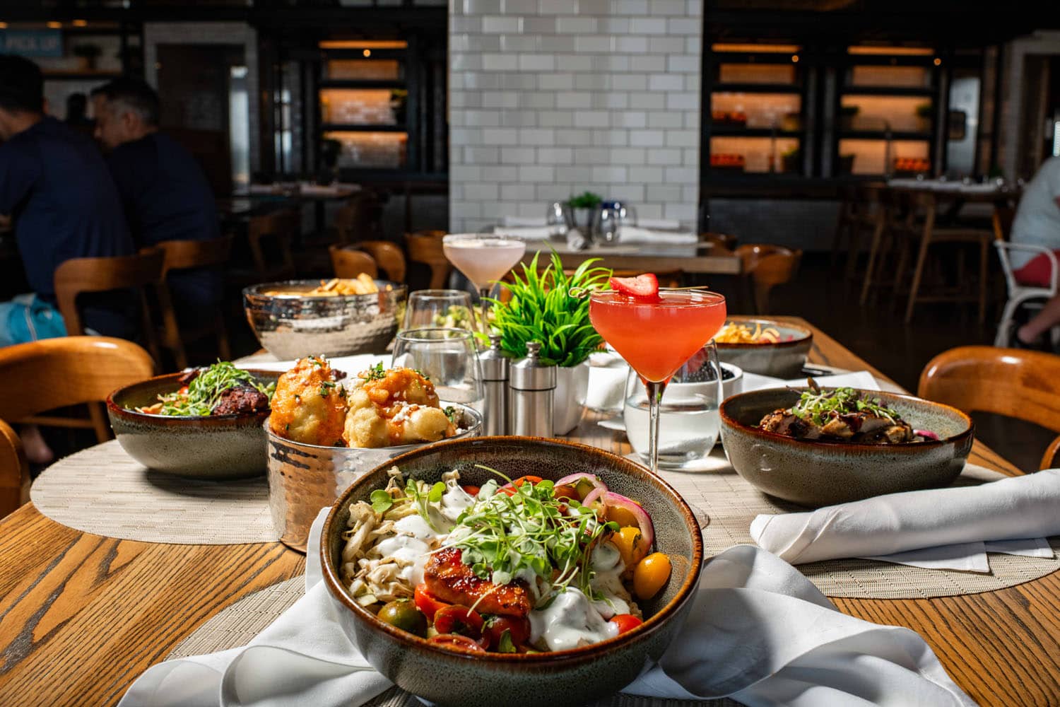 A tableside view of dishes on a table at Tulu Seaside Bar & Grill