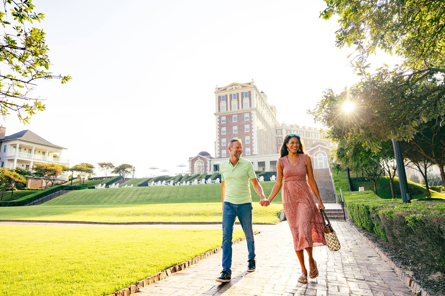A couple holding hands walking outside The Historic Cavalier Hotel