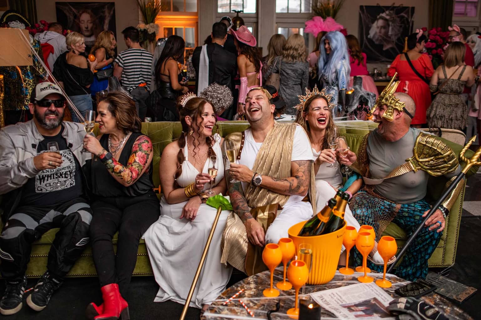 Guests dressed in Halloween costumes in front of a floral display
