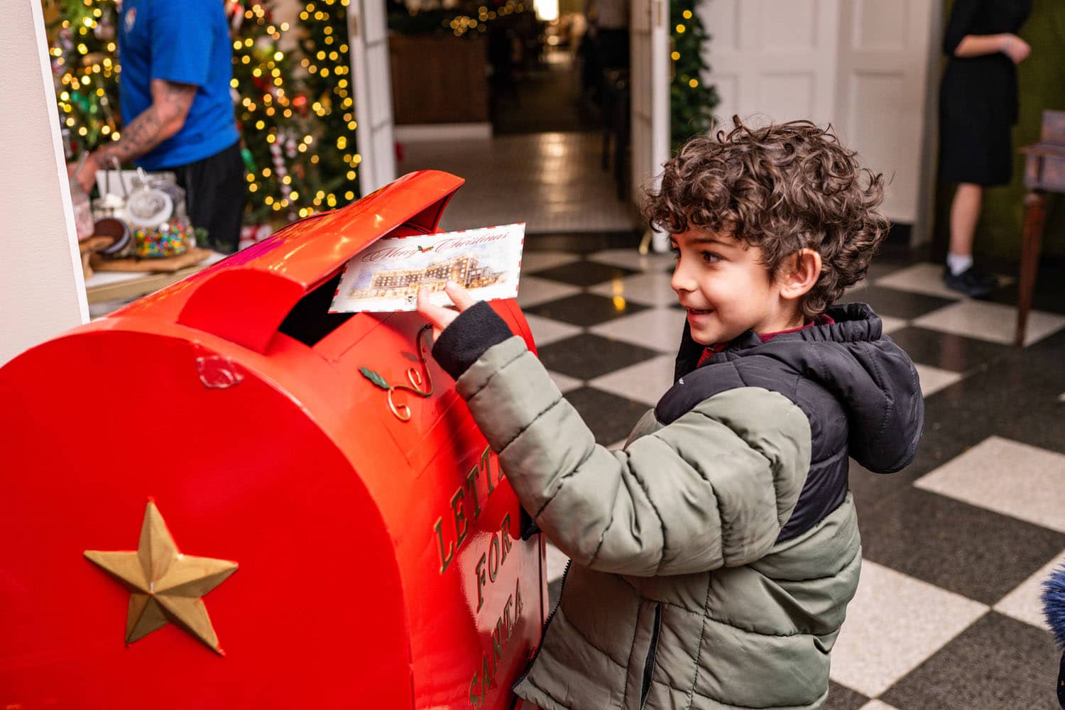 A child putting a letter into a mailbox