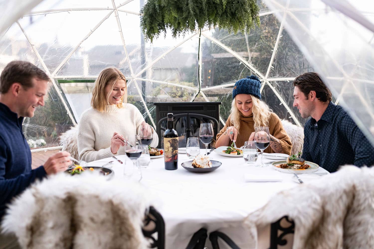 A group of people eating a meal inside a heated igloo