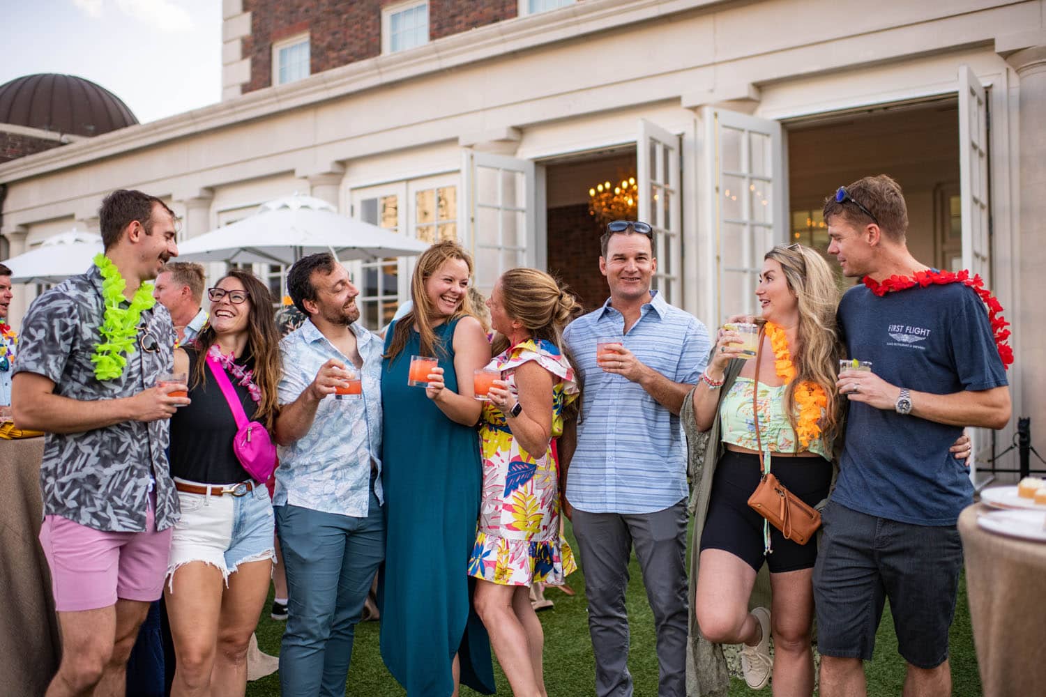 A group of friends smiling and drinking cocktails on the Cavalier Great Lawn