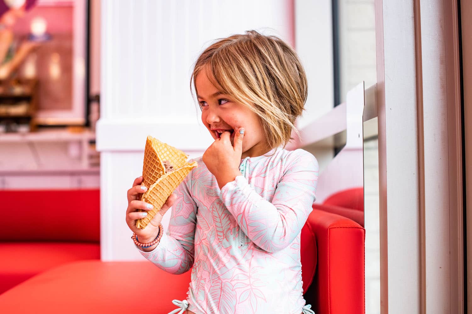 A child eating an ice cream cone inside We Scream Ice Cream and Coffee Shop