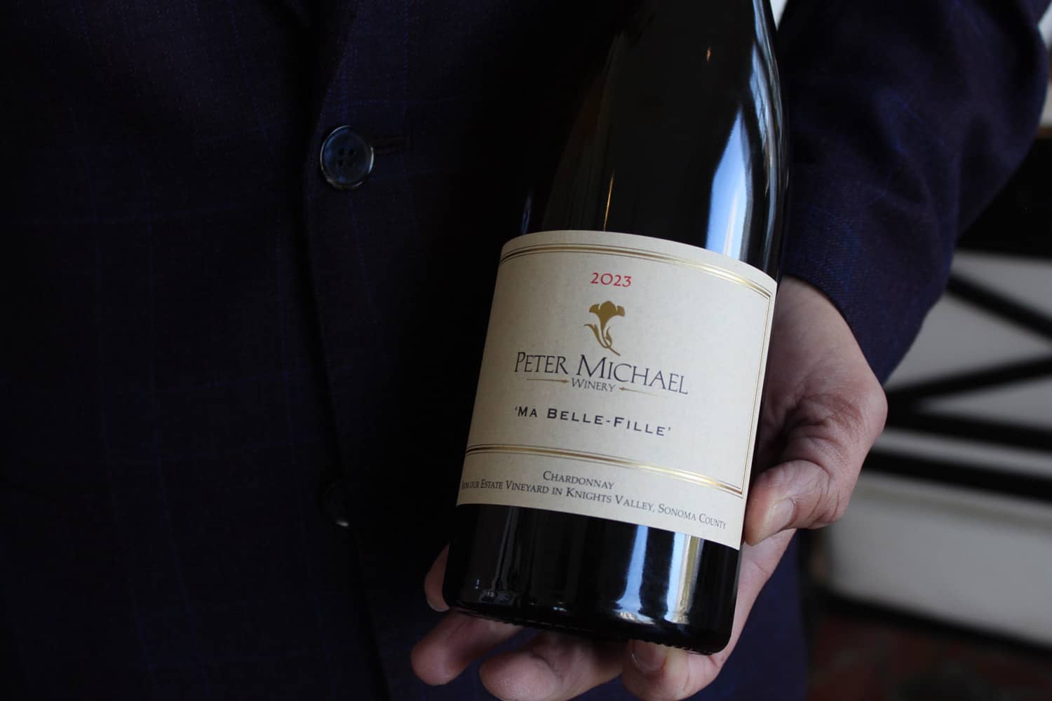 A close-up bottle of wine in a sommelier's hands