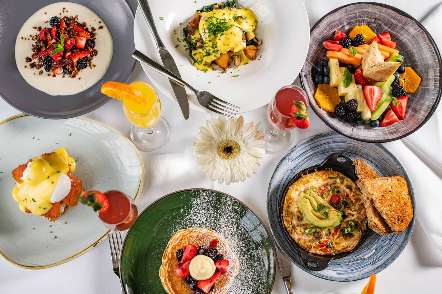 A variety of breakfast dishes on a table at Becca Restaurant & Garden