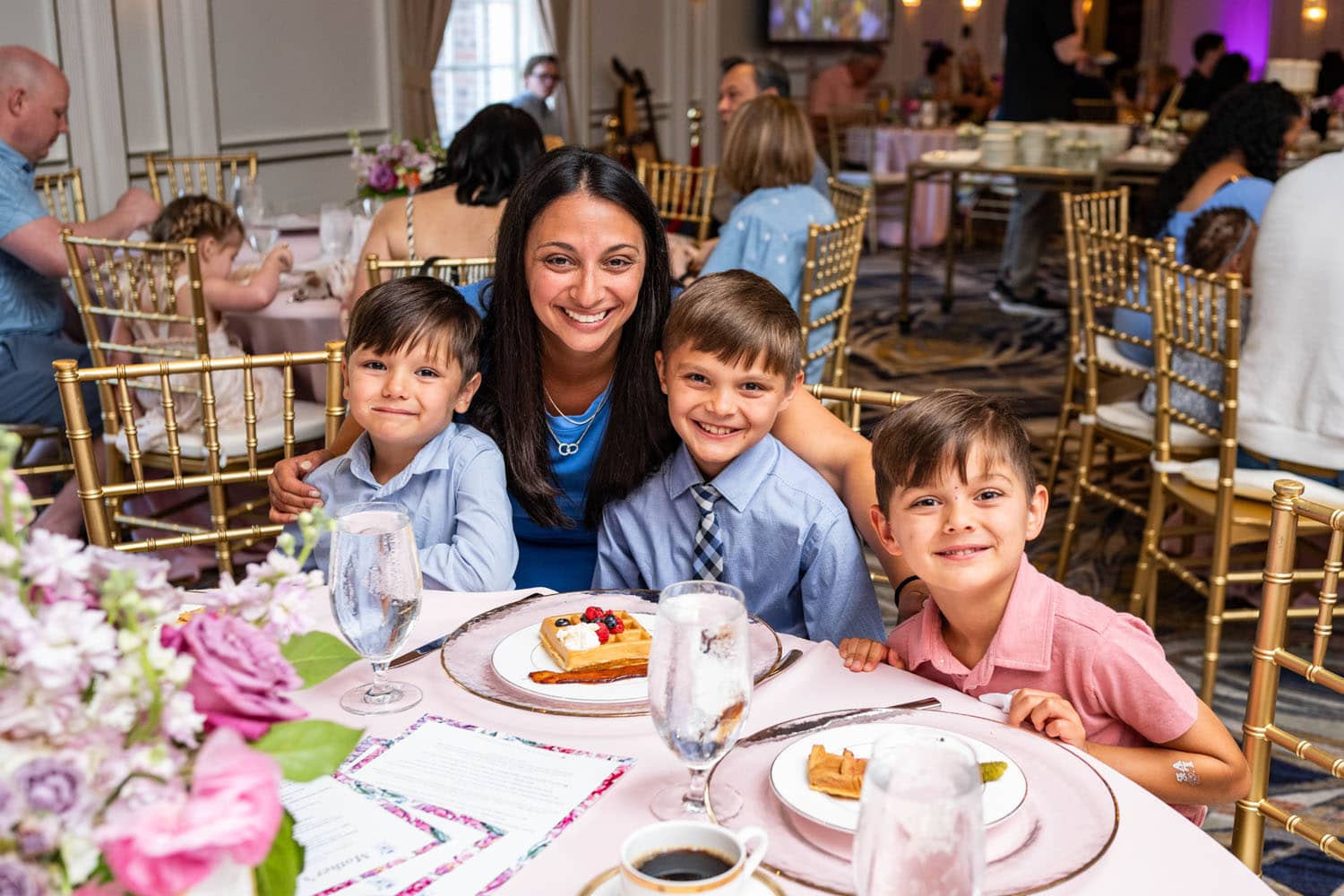 A mom posing for photos with her children at a Mother's Day buffet