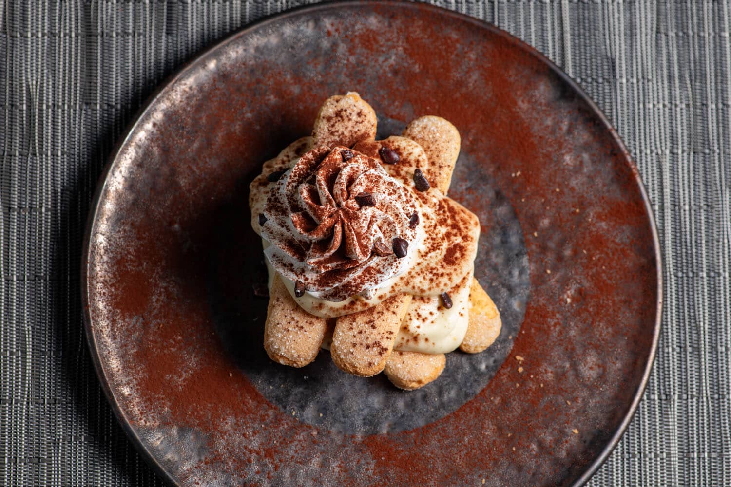 Tiramisu topped with mascarpone cream, cocoa, and chocolate at Tulu Seaside Bar & Grill